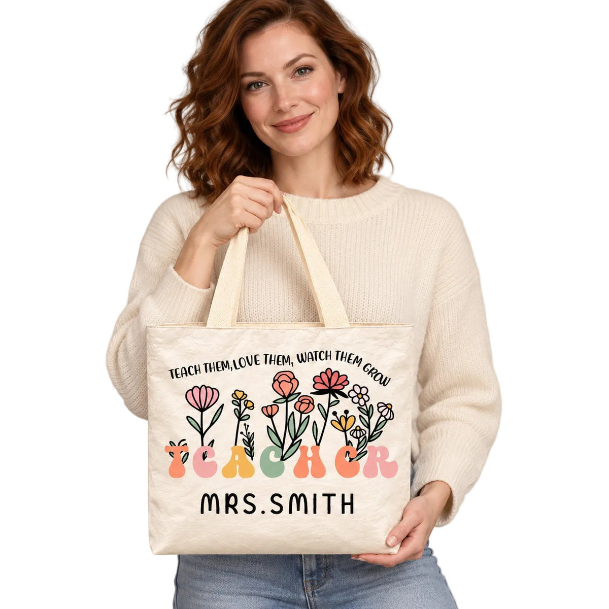 Personalized teacher tote with floral teacher artwork with the phrase TEACH THEM, LOVE THEM, WATCH THEM GROW and custom name MRS.SMITH, hero view.