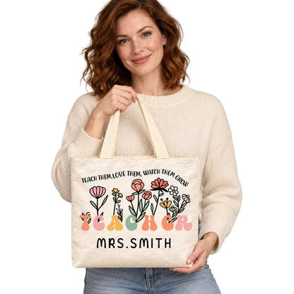 Personalized teacher tote with floral teacher artwork with the phrase TEACH THEM, LOVE THEM, WATCH THEM GROW and custom name MRS.SMITH, hero view.