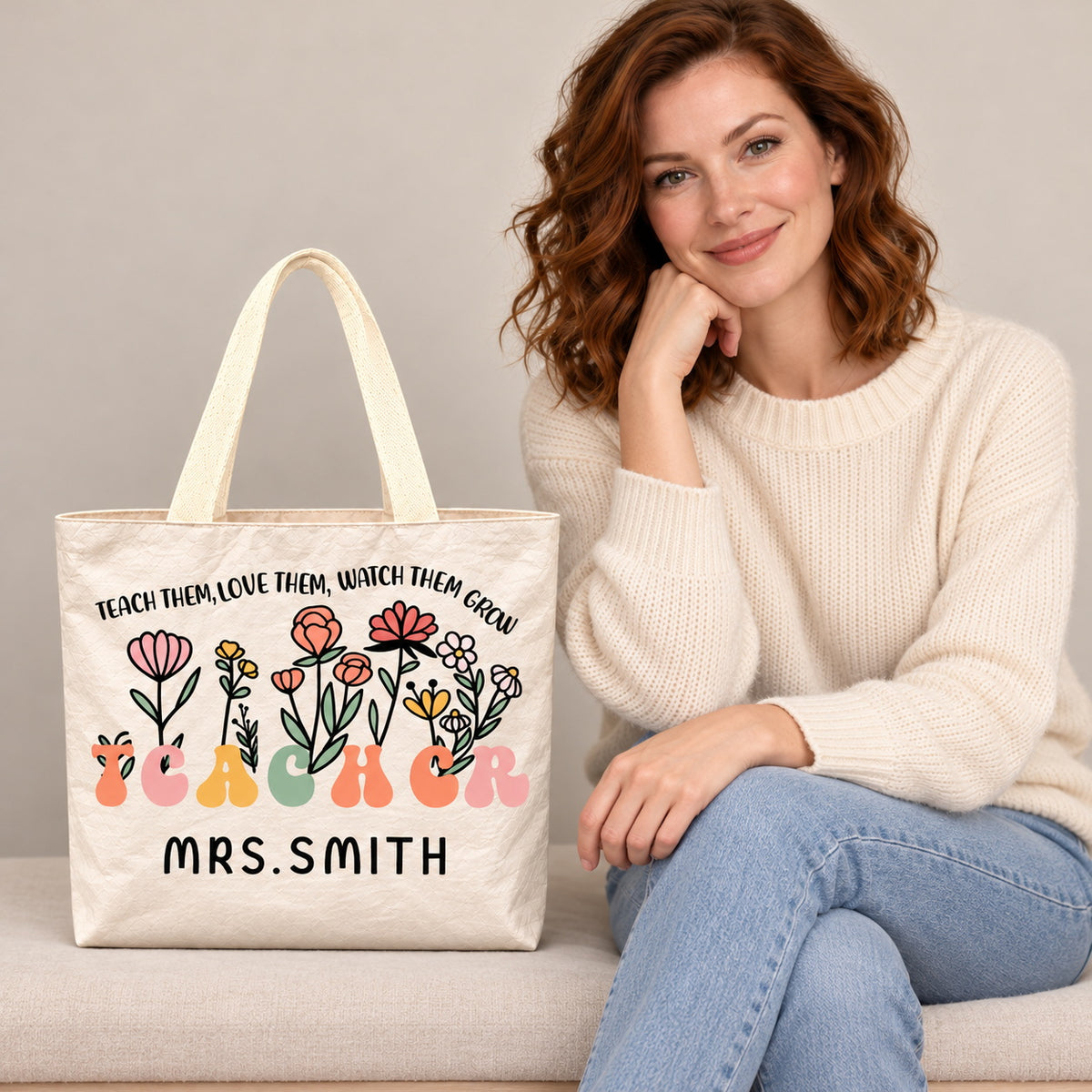 Personalized teacher tote with floral teacher artwork with the phrase TEACH THEM, LOVE THEM, WATCH THEM GROW and custom name MRS.SMITH, custom name detail view.