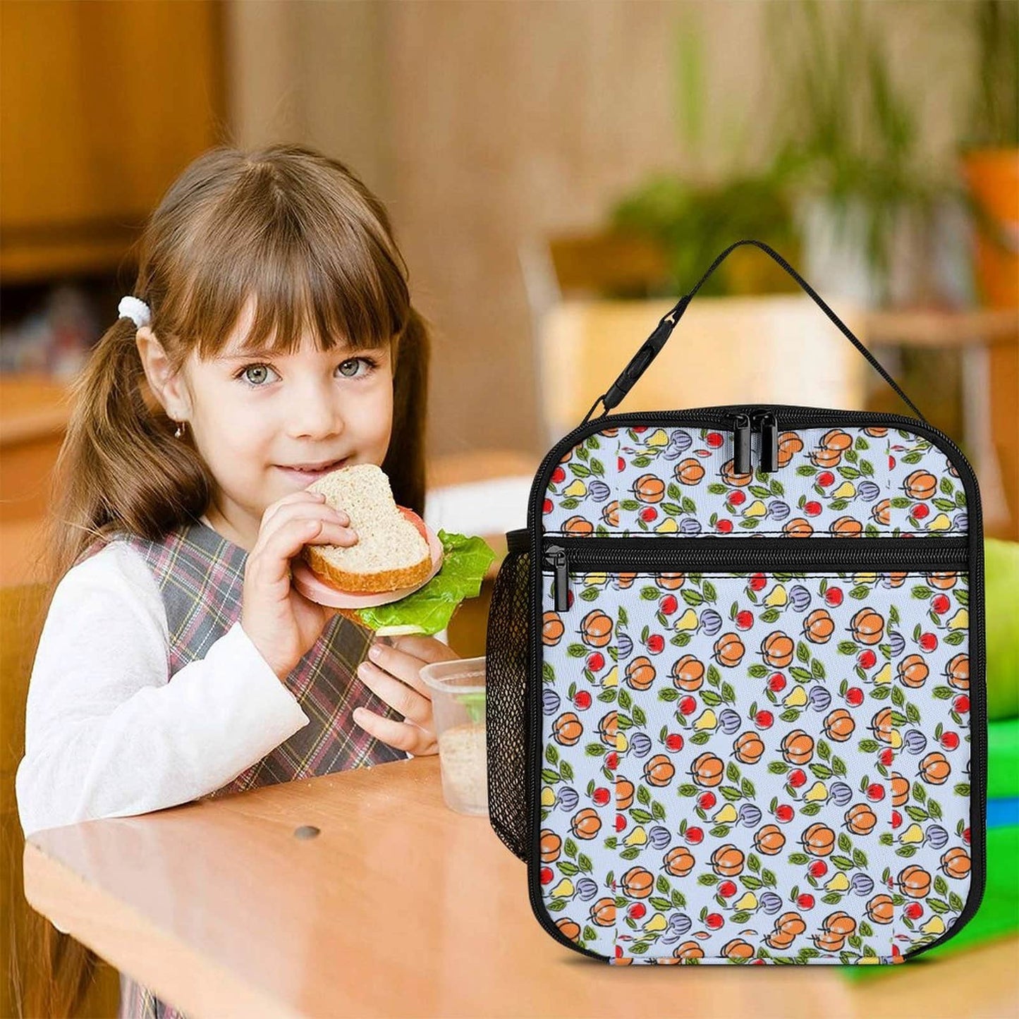 Thermal Lunch Bag for Work used by a girl eating a sandwich at a desk.