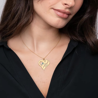 Model wearing the gold plated two hearts personalized necklace with custom names and blue birthstones on a black top.