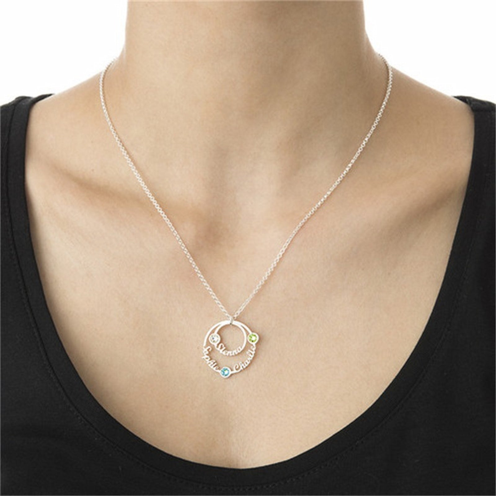 Woman wearing personalized circle name birthstone necklace with 3 custom names.