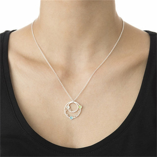 Woman wearing personalized circle name birthstone necklace with 3 custom names.