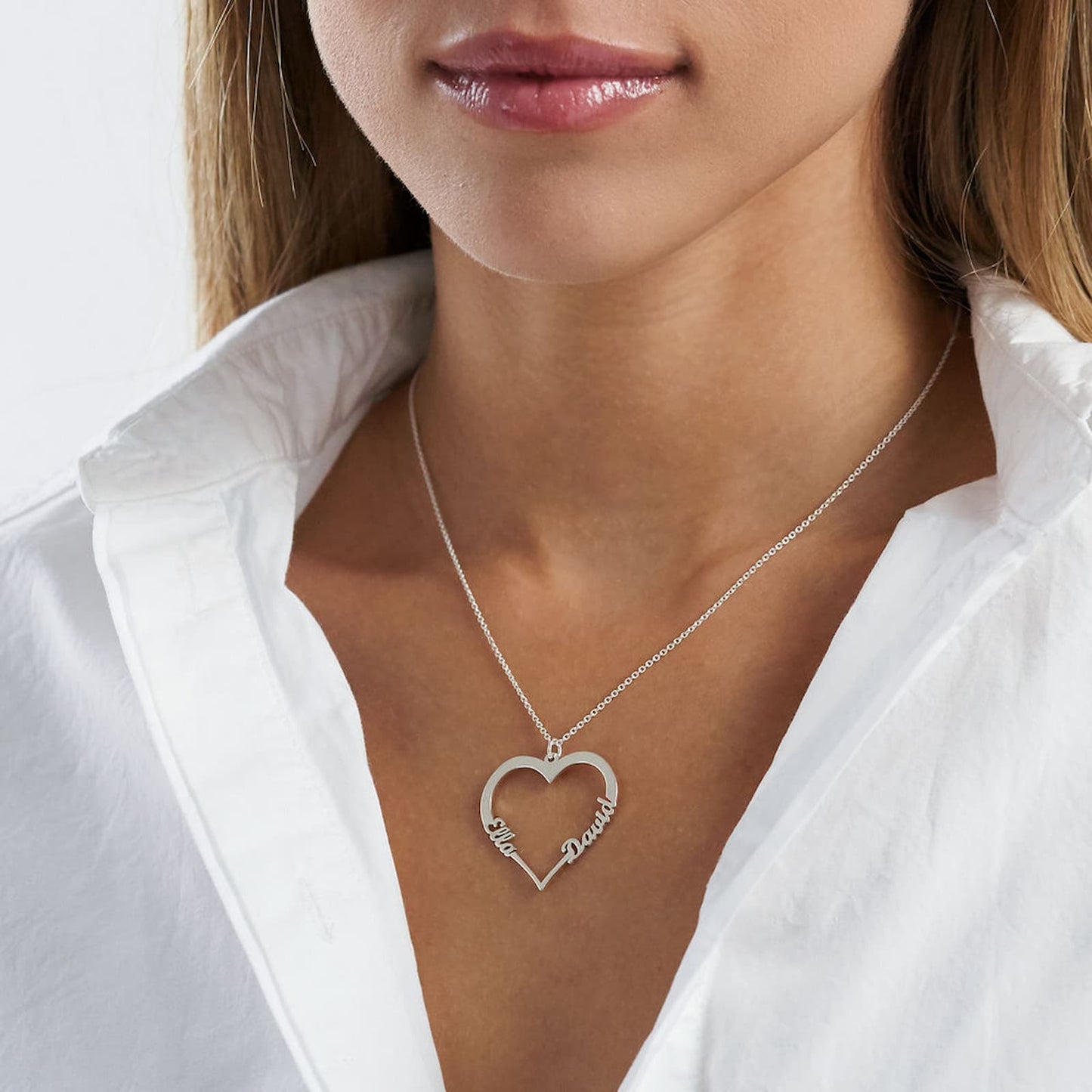 Woman wearing personalized heart name necklace in silver, custom names.