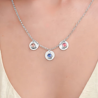 Model wearing rose gold multi-charm engraved necklace with birthstones and text.