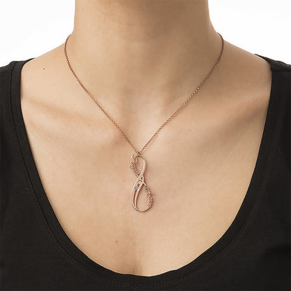 Woman wearing rose gold infinity birthstone name necklace with two custom names.