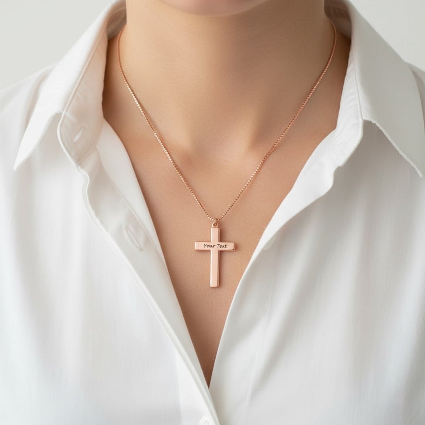 Woman wearing rose gold personalized cross necklace. Custom engraved text on plain cross pendant.