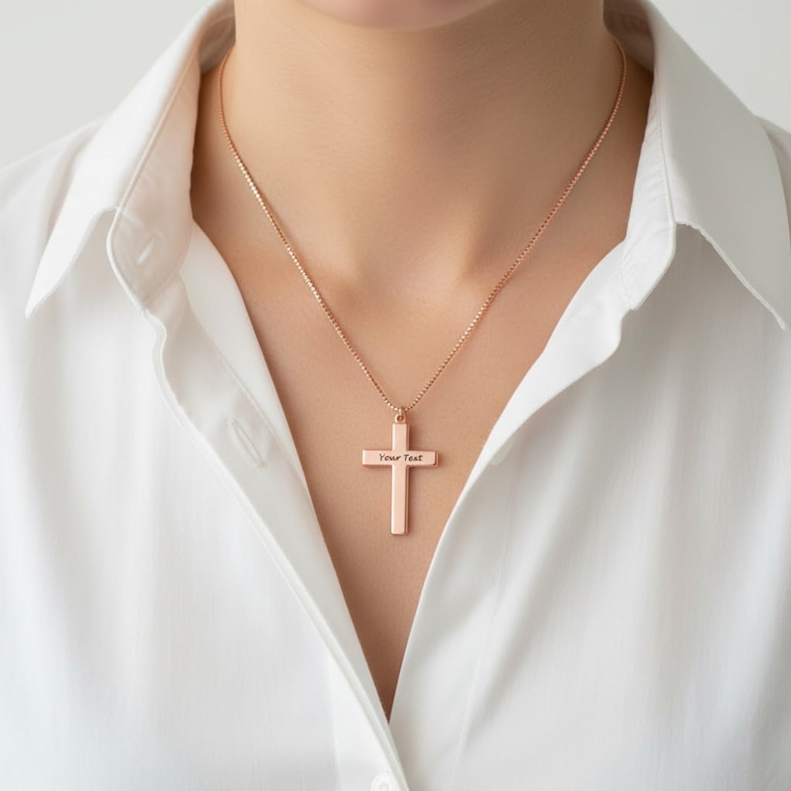 Woman wearing rose gold personalized cross necklace. Custom engraved text on plain cross pendant.