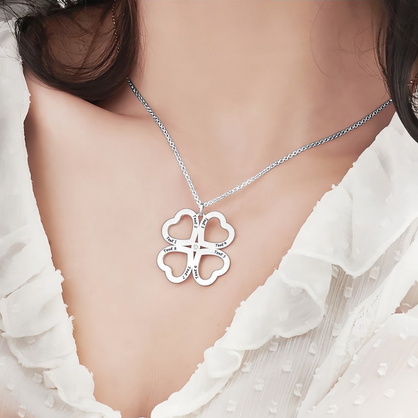 Woman wearing silver engraved four heart clover necklace with custom text.