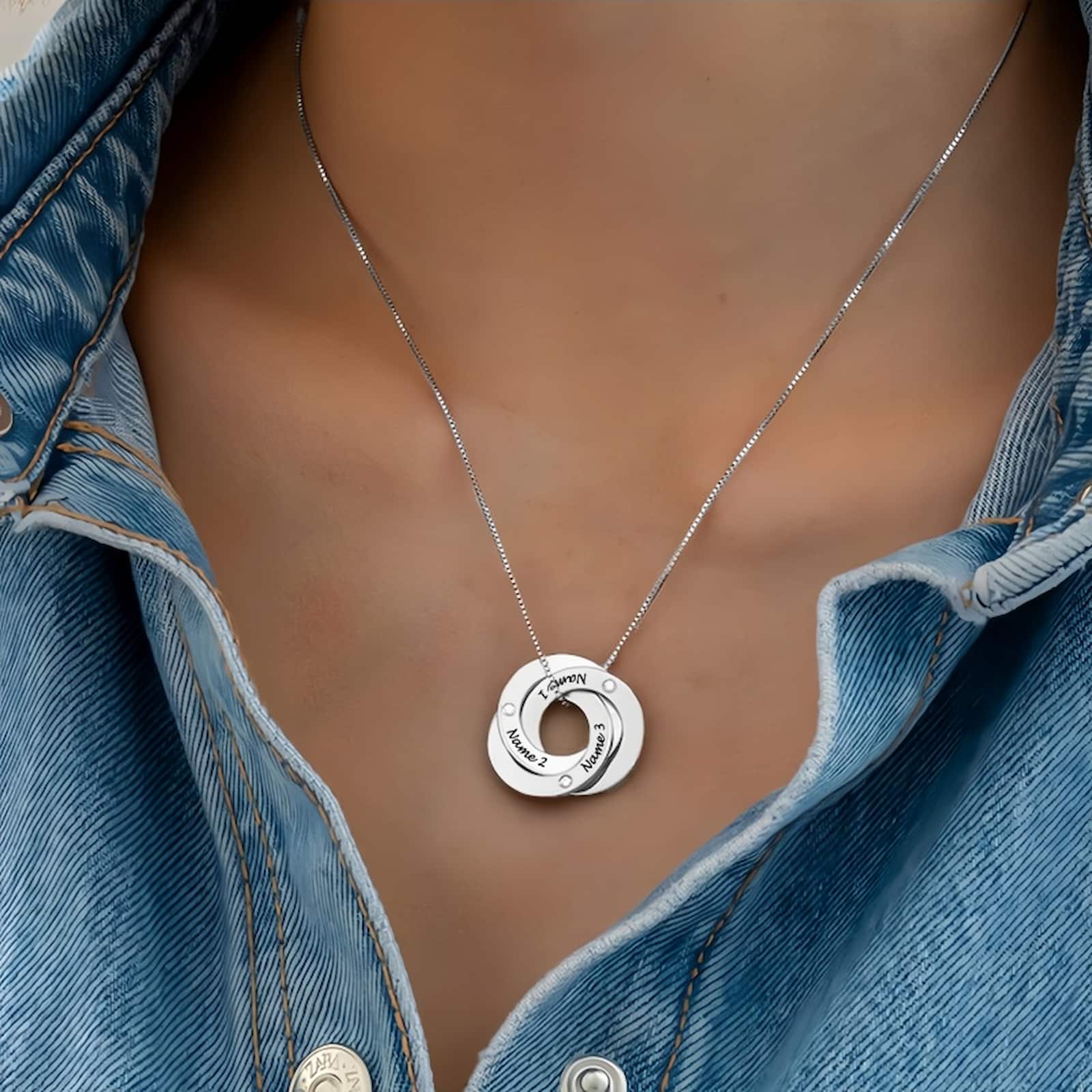 Woman wearing silver interlocking name necklace. Personalized 3 rings with custom names.