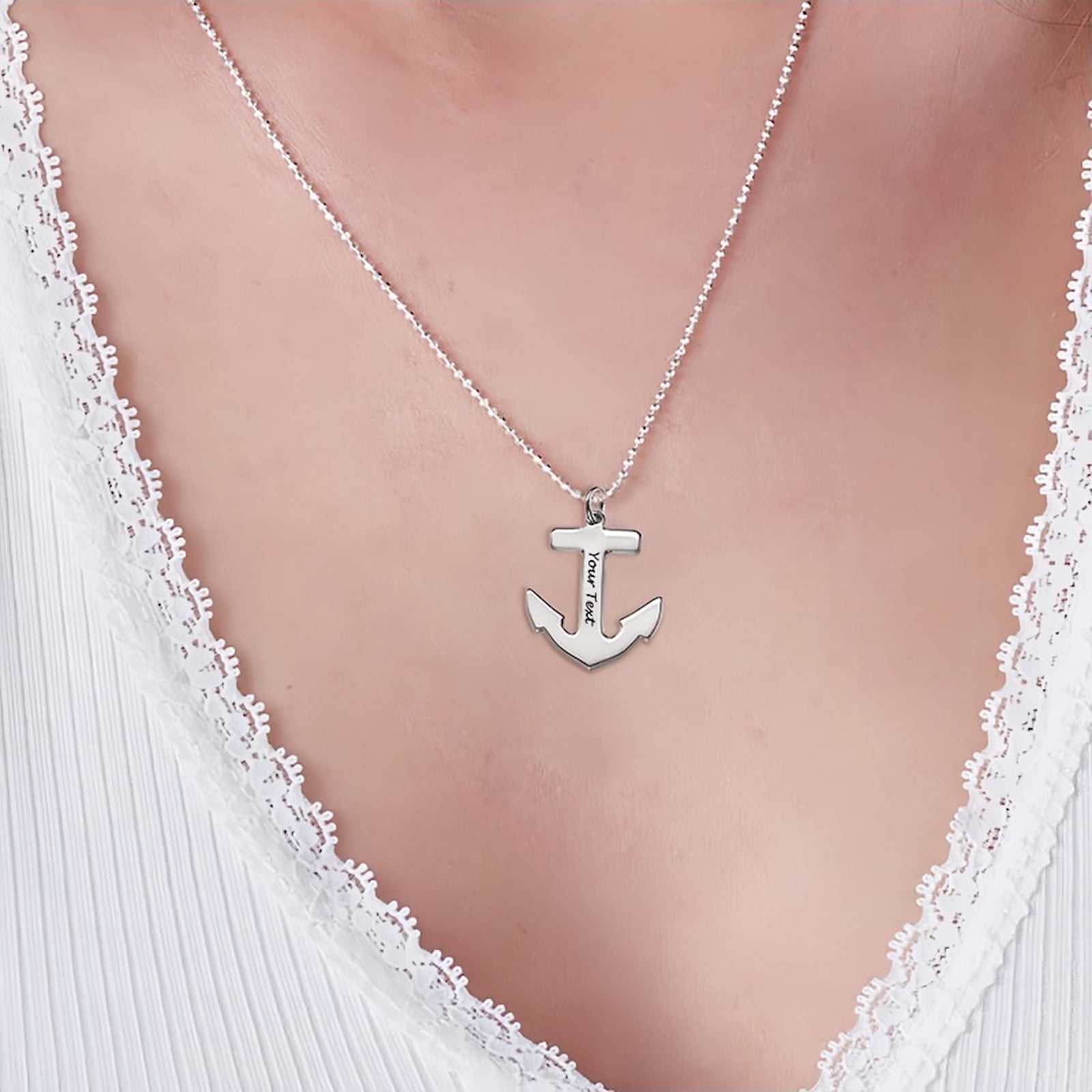 Woman wearing silver personalized anchor necklace with custom text on ball chain.