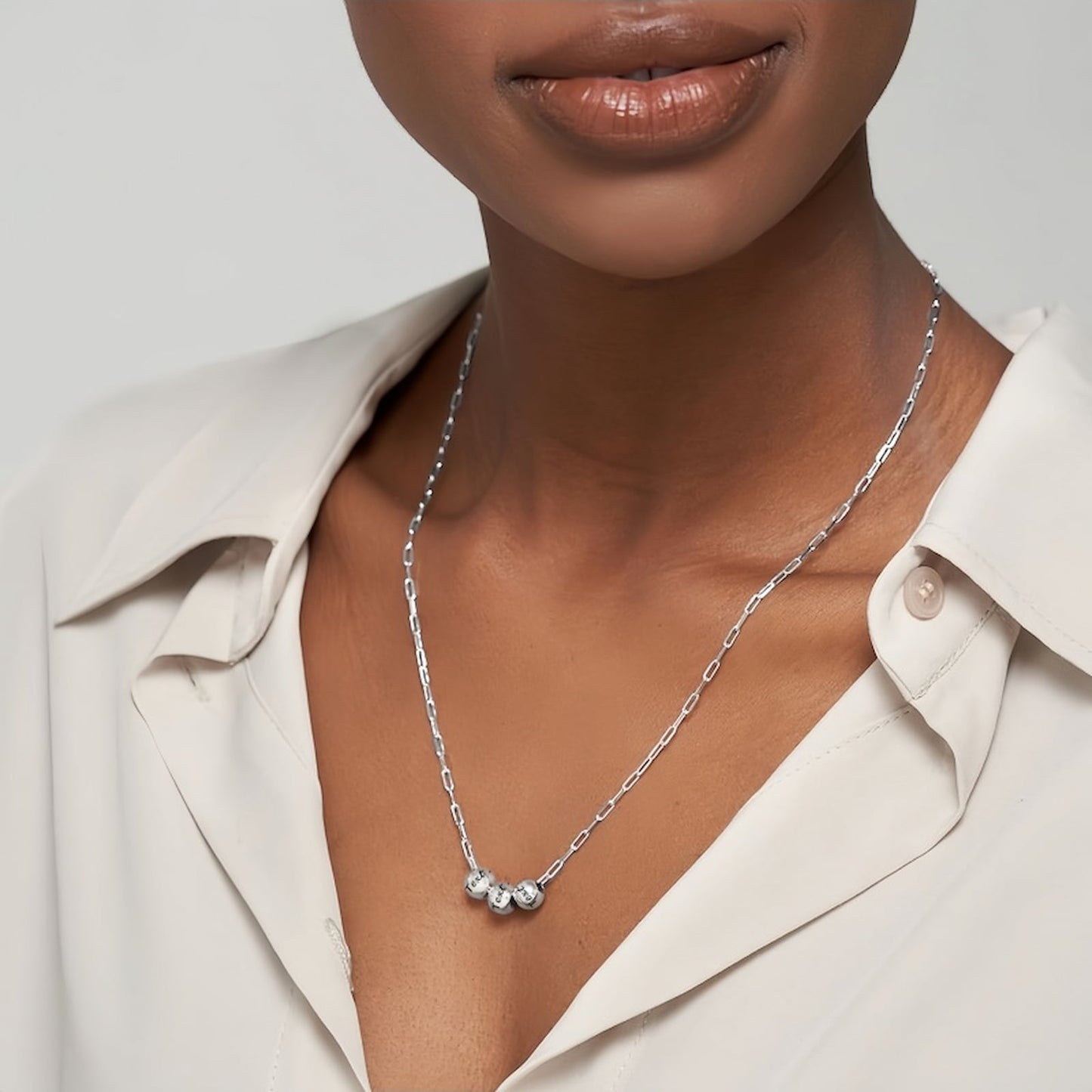 Woman wearing silver personalized bead paperclip necklace. Engraved names, modern style.