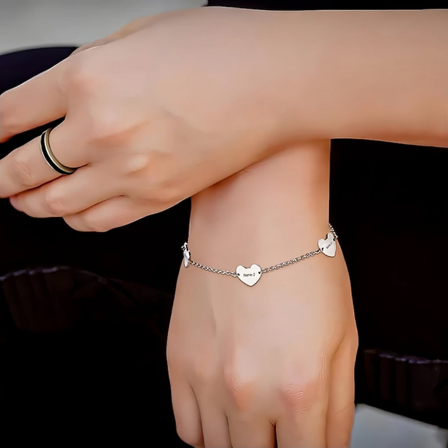 Close-up of a woman wearing the S925 silver personalized hearts charm bracelet with custom name hearts, showcasing its elegant fit.