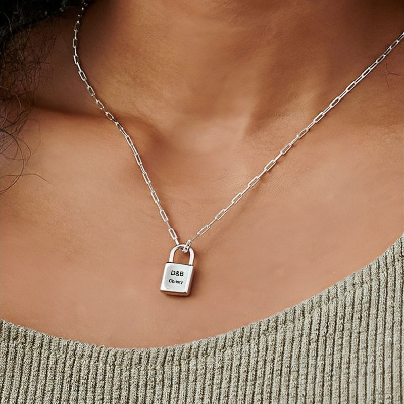 Woman wearing silver personalized lock necklace with custom initials & name on paperclip chain.