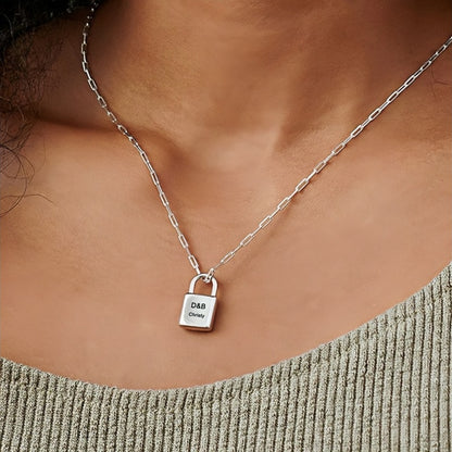 Woman wearing silver personalized lock necklace with custom initials & name on paperclip chain.