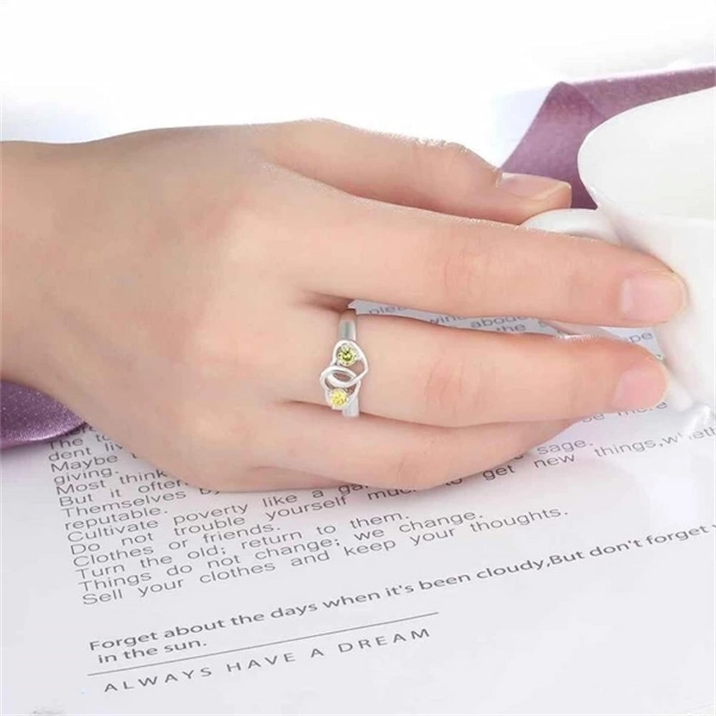 Woman wearing sterling silver intertwined heart promise ring with custom names.