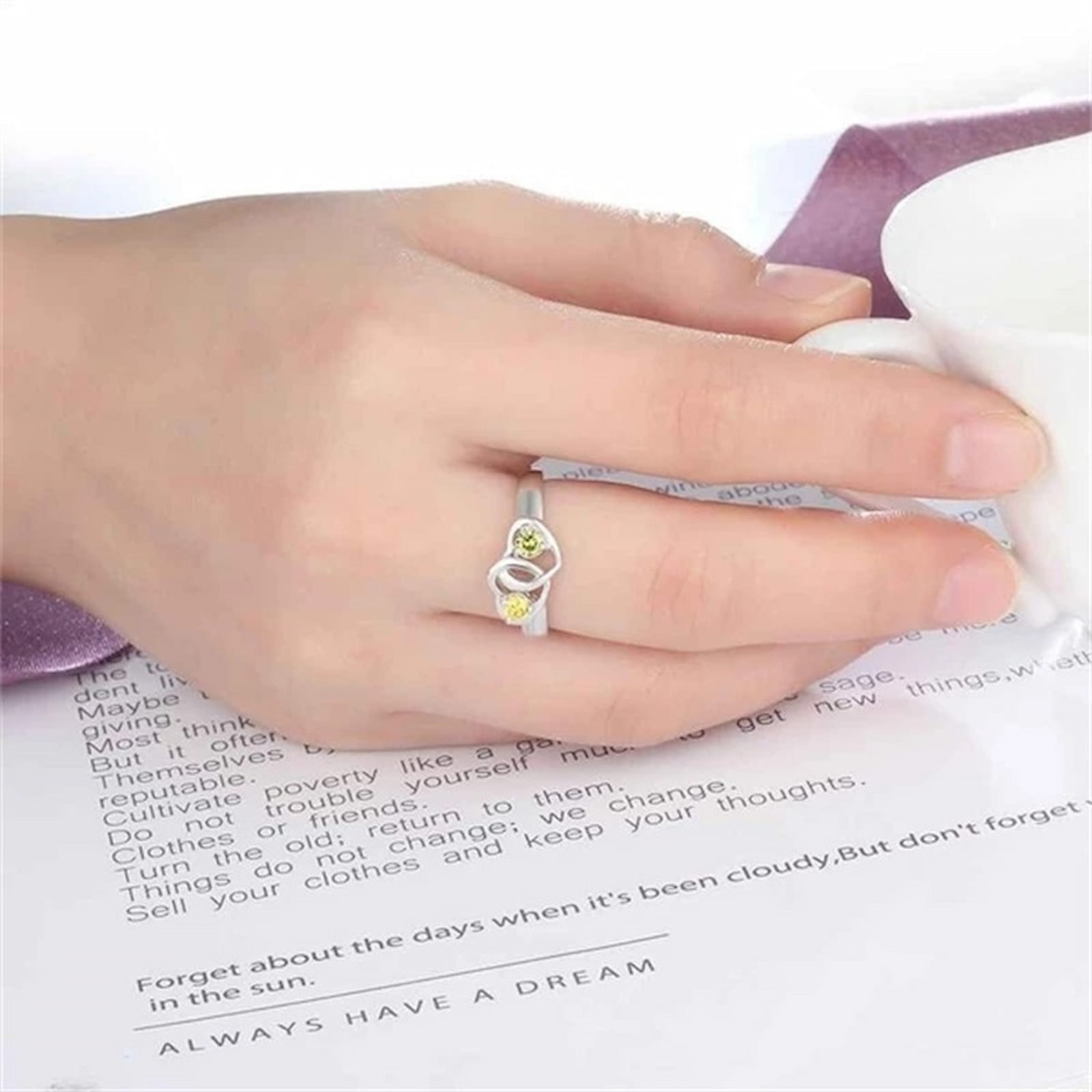 Woman wearing sterling silver intertwined heart promise ring with custom names.